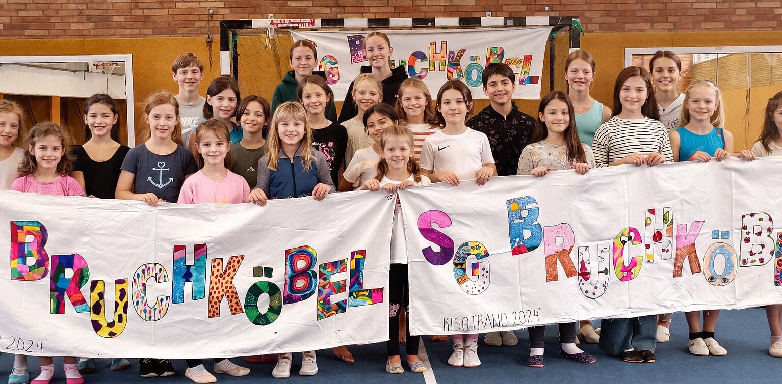 : Detailaufnahme der Füße einer Turnerin beim Balancieren auf einem Schwebebalken in der Sporthalle.